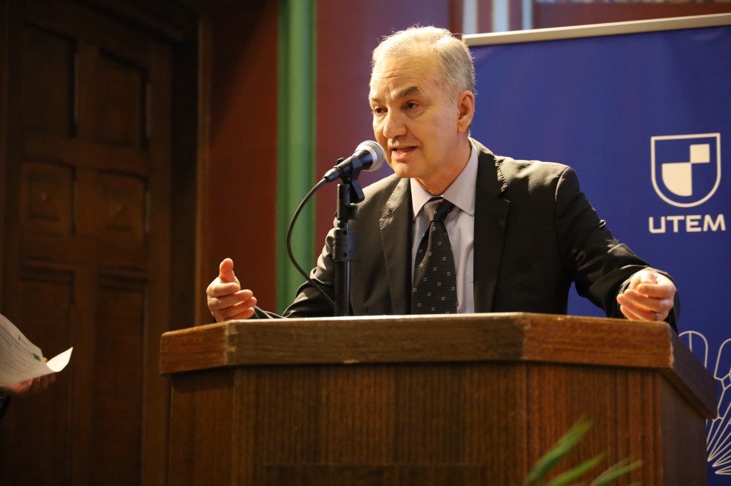 Discurso de autoridad en la ceremonia del Premio Sustenta UTEM. Figura de liderazgo de la UTEM en el podio, enfatizando el rol de la universidad en la Vinculación con el Medio y el fomento de la sustentabilidad corporativa y ESG en Chile.